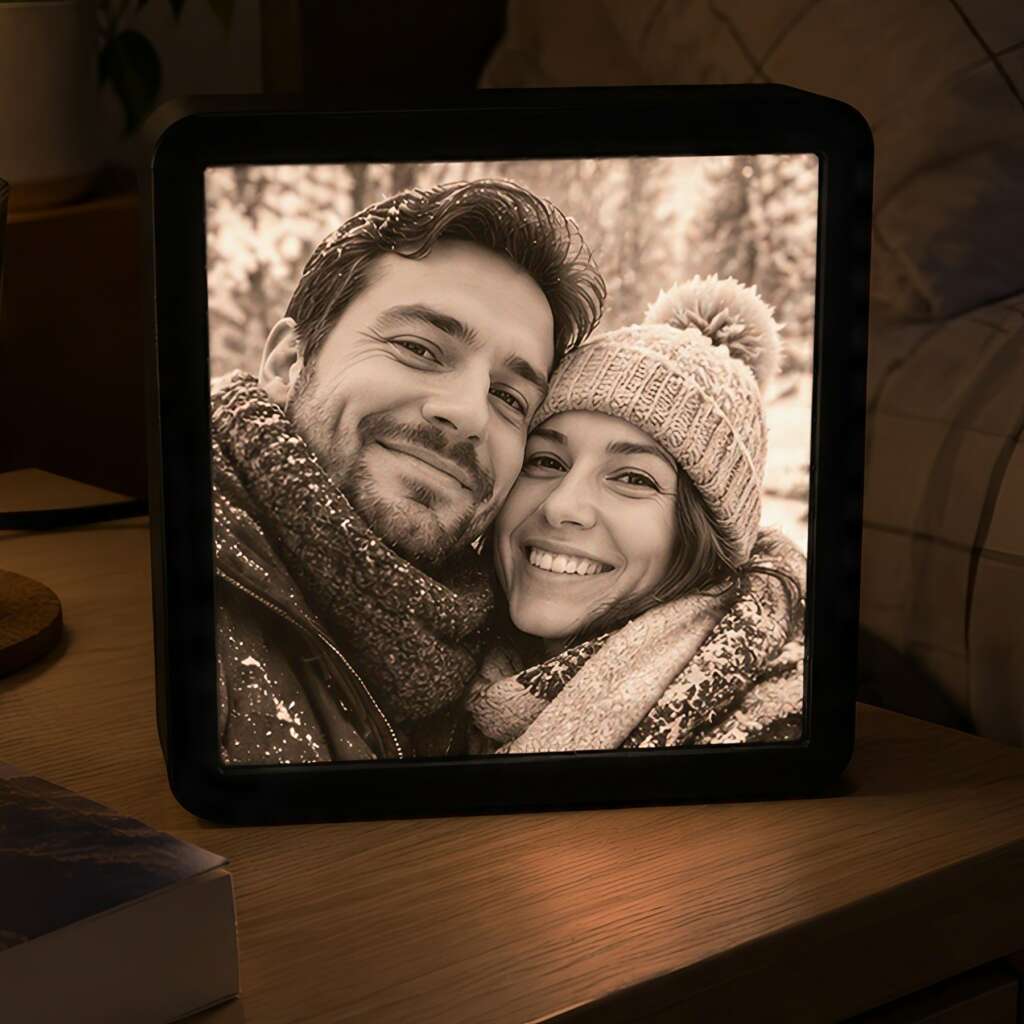 Cadre LED carré 16 × 16 cm avec une photo de couple, posé sur une table.